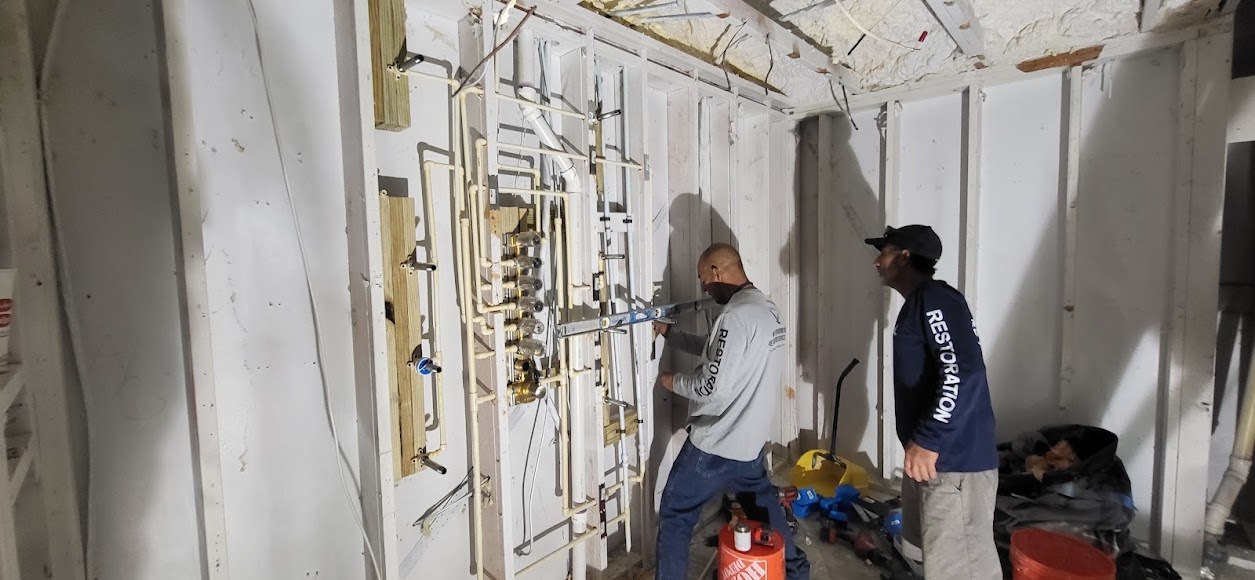 Crew working inside an opened interior wall area